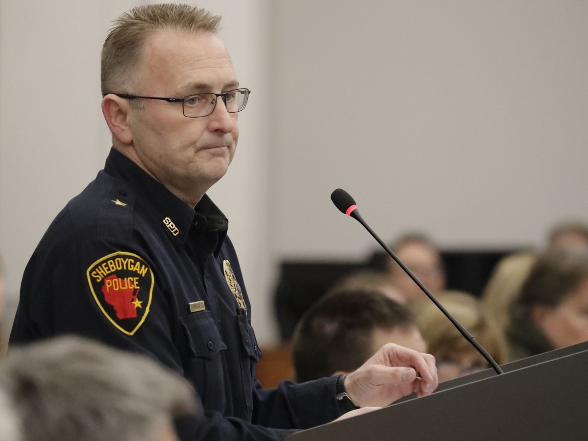 A police officer addresses a crowd.