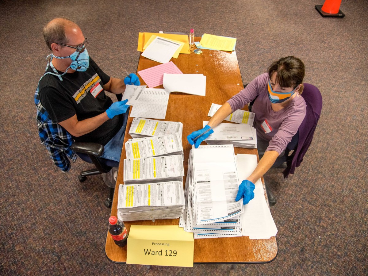 Election workers Jeff and Lori Lutzka process absentee ballots at Milwaukee's central count facility on Aug. 11, 2020.