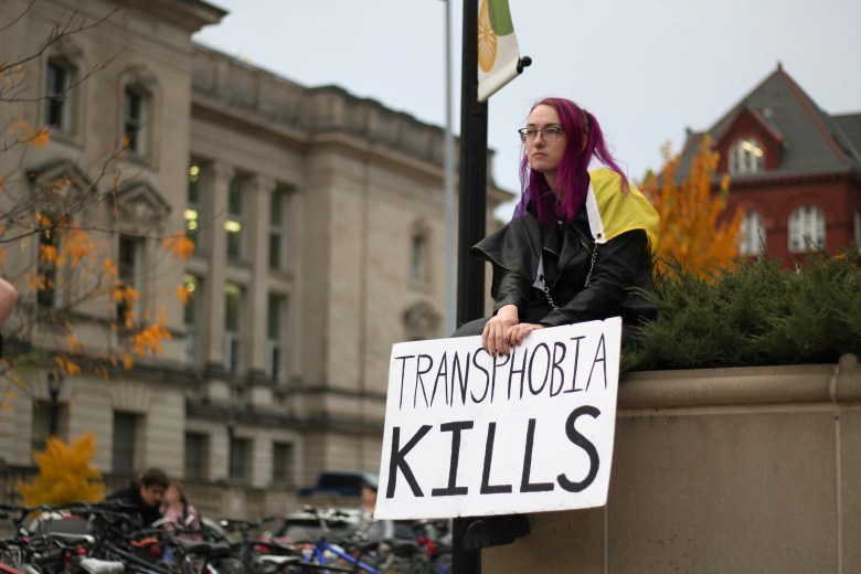 A protester holds a sign opposing anti-trans activist and self-described “theocratic fascist” Matt Walsh.